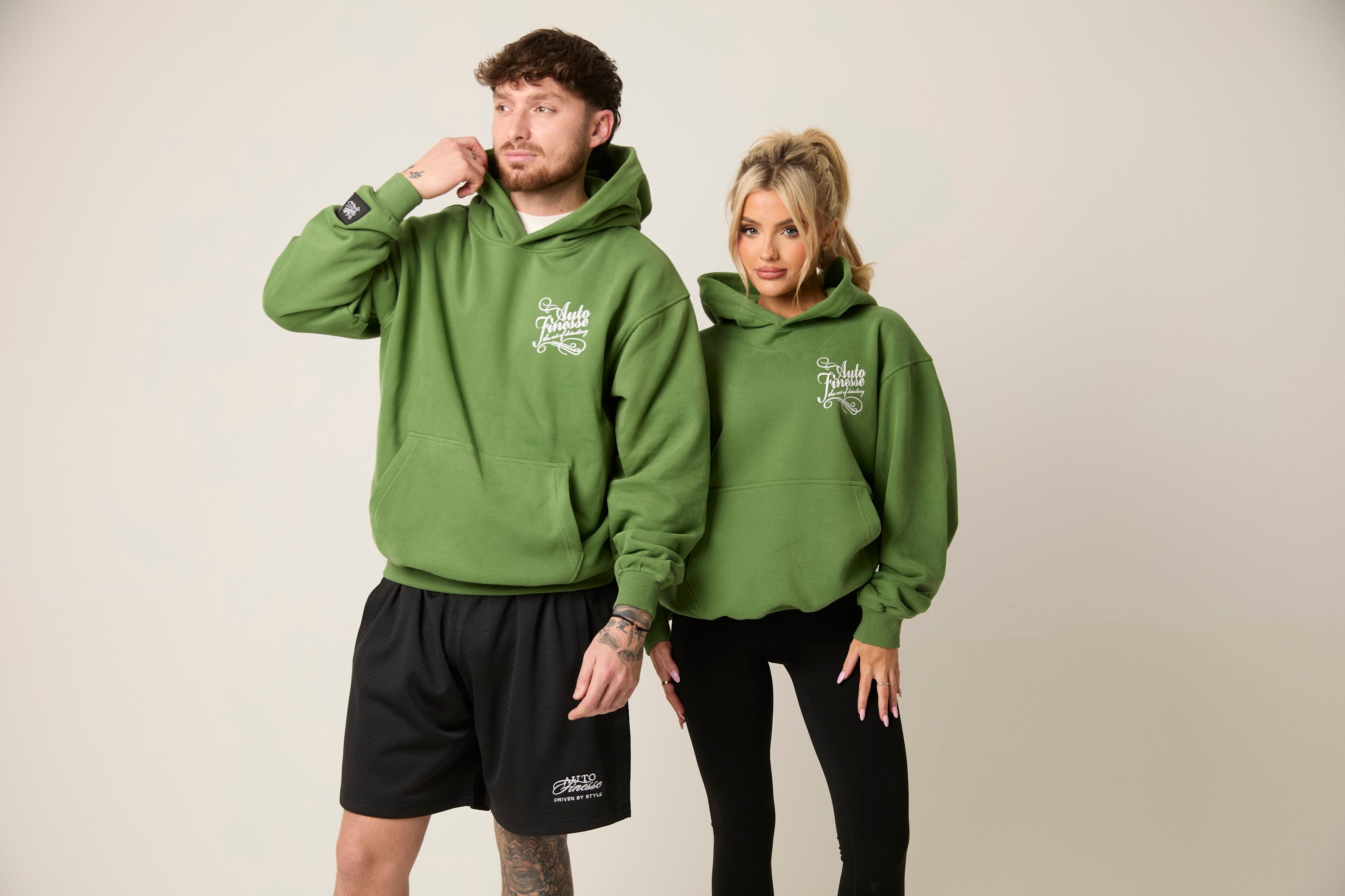 Man & Woman in green Auto Finesse hoodies with sporty outfits