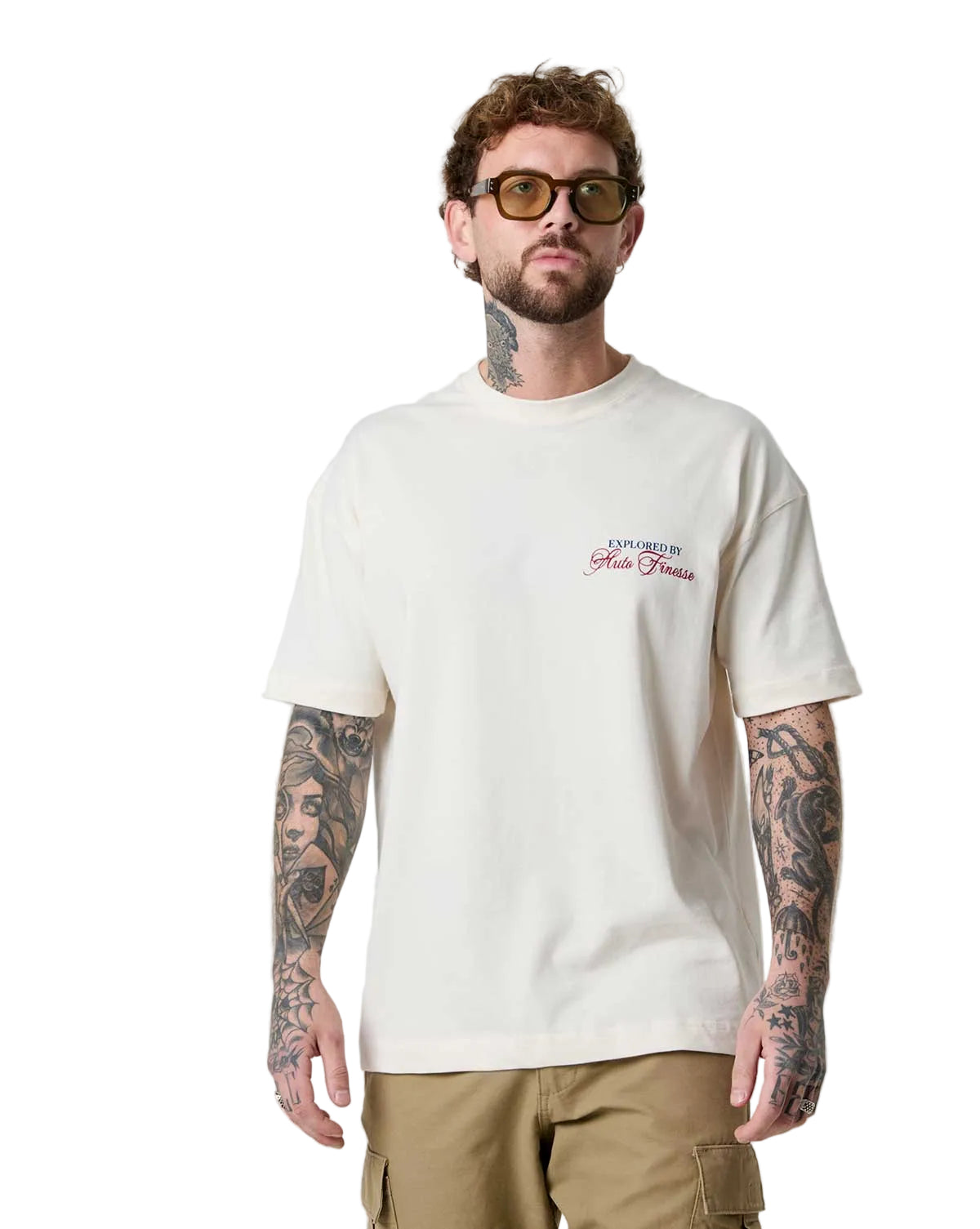 Man wearing a cream t-shirt with a logo on a white background