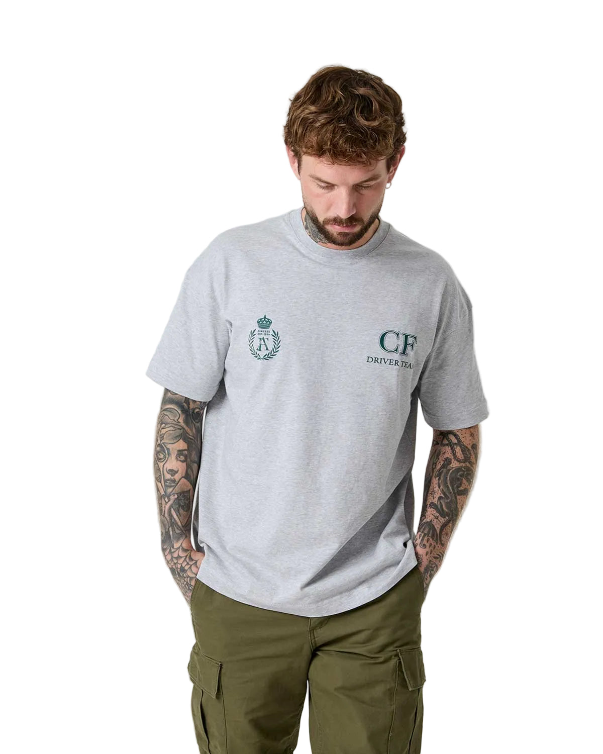 Man wearing a gray t-shirt with logos and green cargo pants on a white background