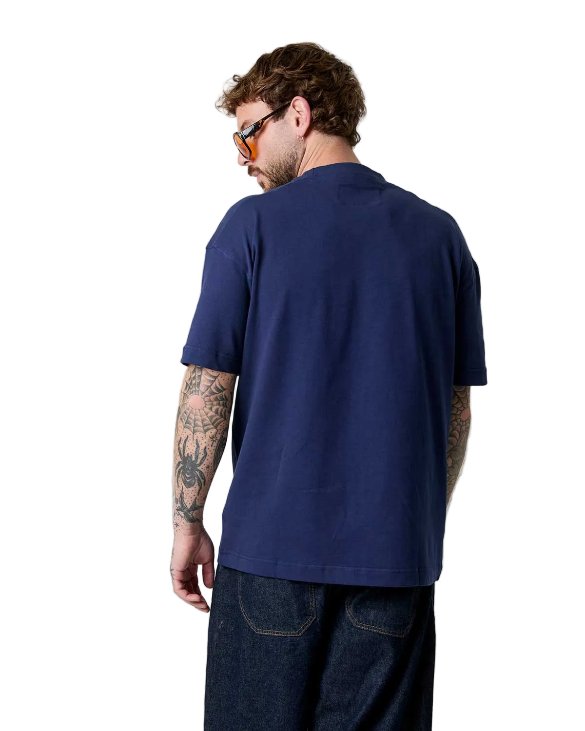 Man wearing a navy blue polo shirt on a plain background