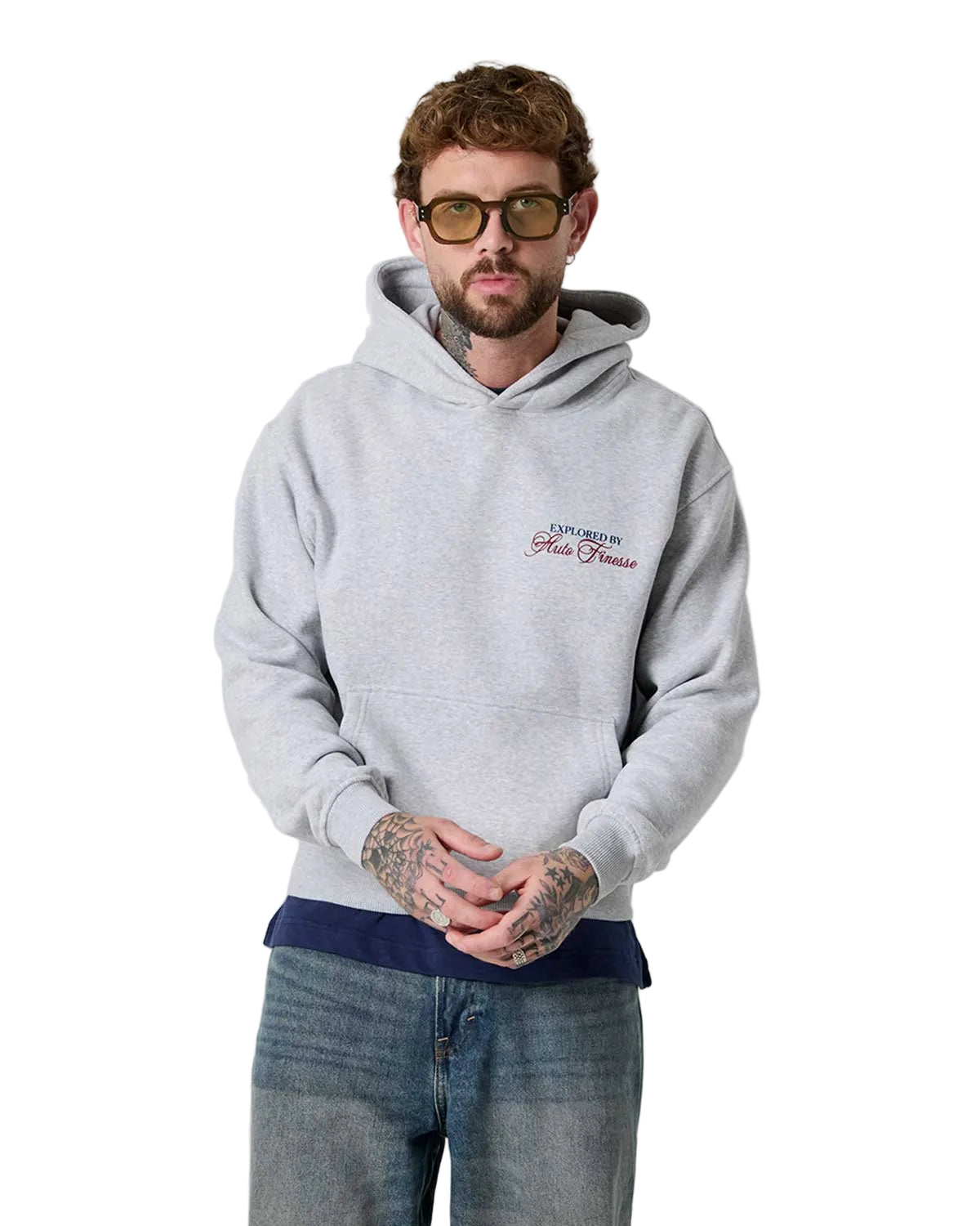 Man wearing a gray hoodie with a logo on a plain background