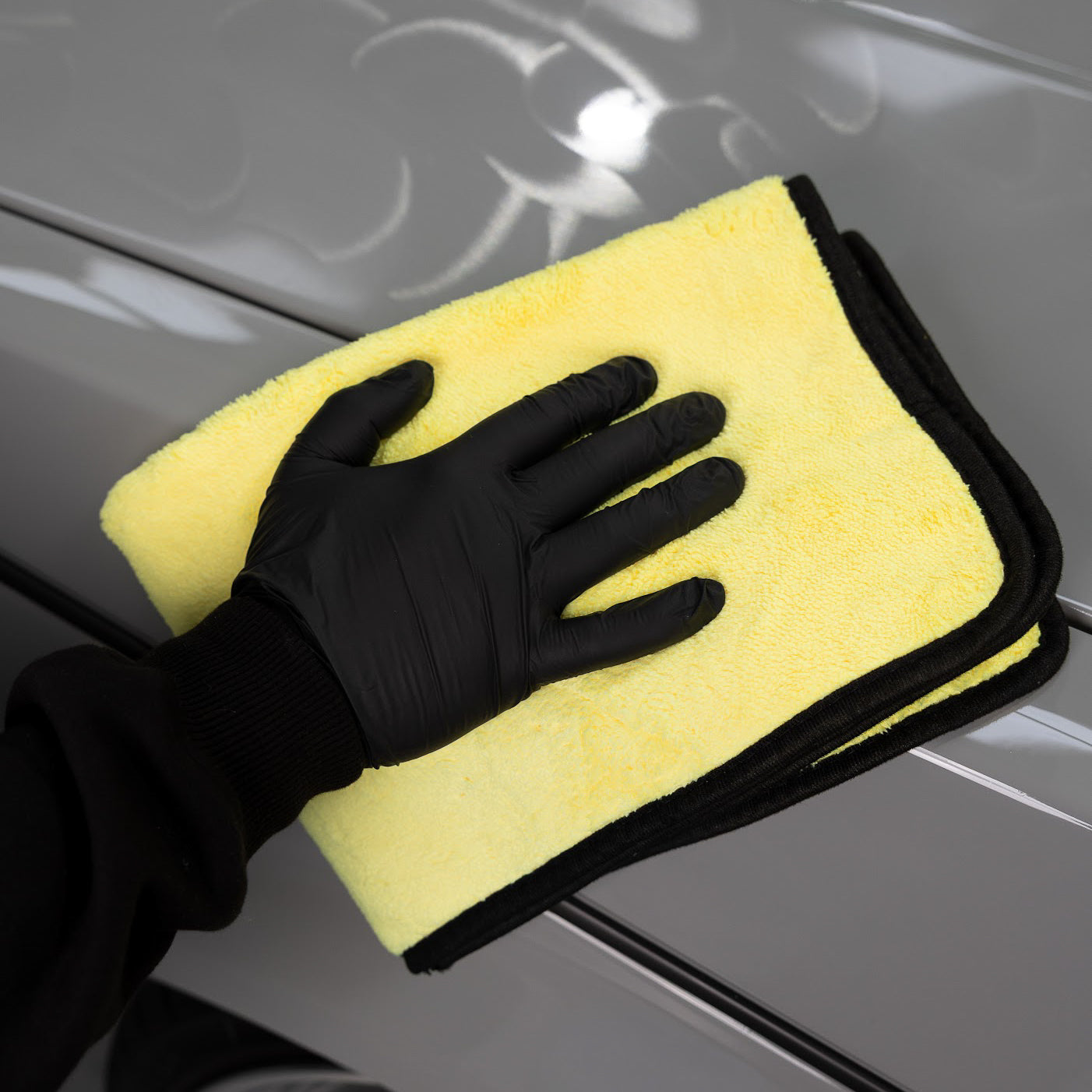 Wiping down car surface with a yellow microfiber cloth_ Car Wax Kit