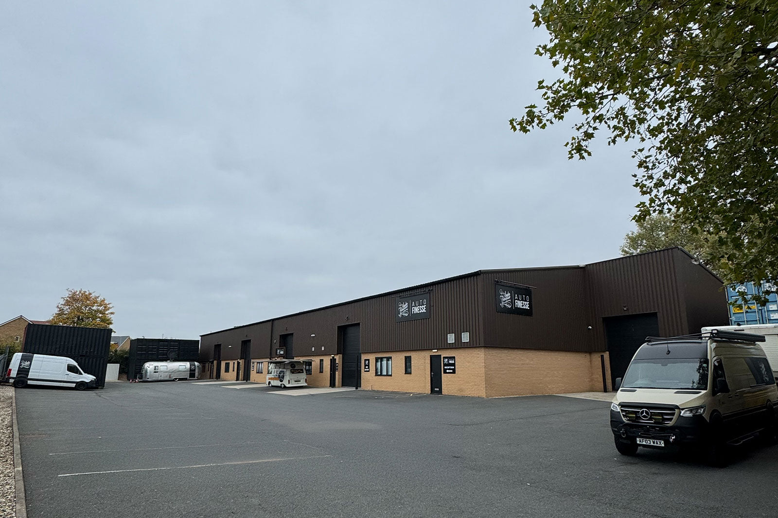 Commercial building with parked vehicles on a cloudy day