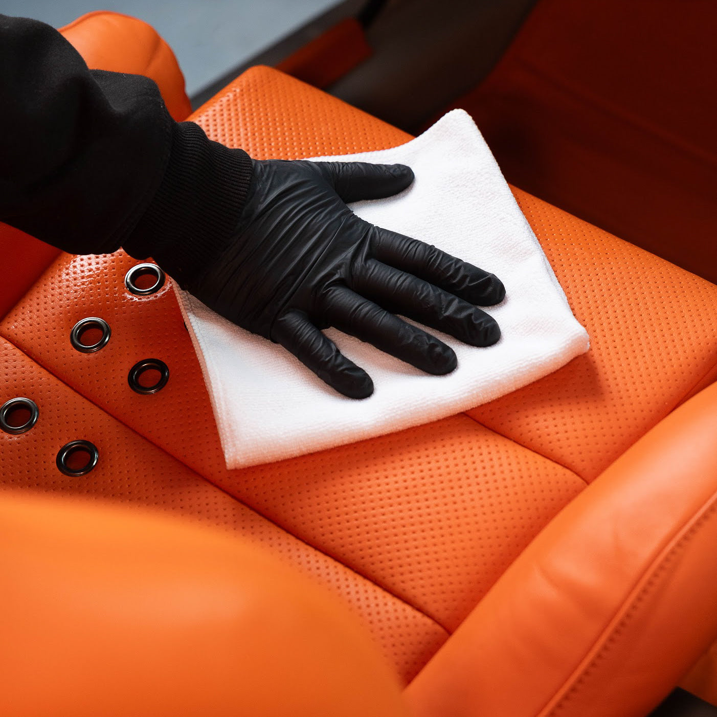 Wiping leather seat with a clean microfibre cloth after cleaning_ Leather Cleaning Kit