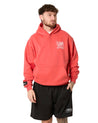 Man wearing a red hoodie and black shorts with a brand logo on a white background