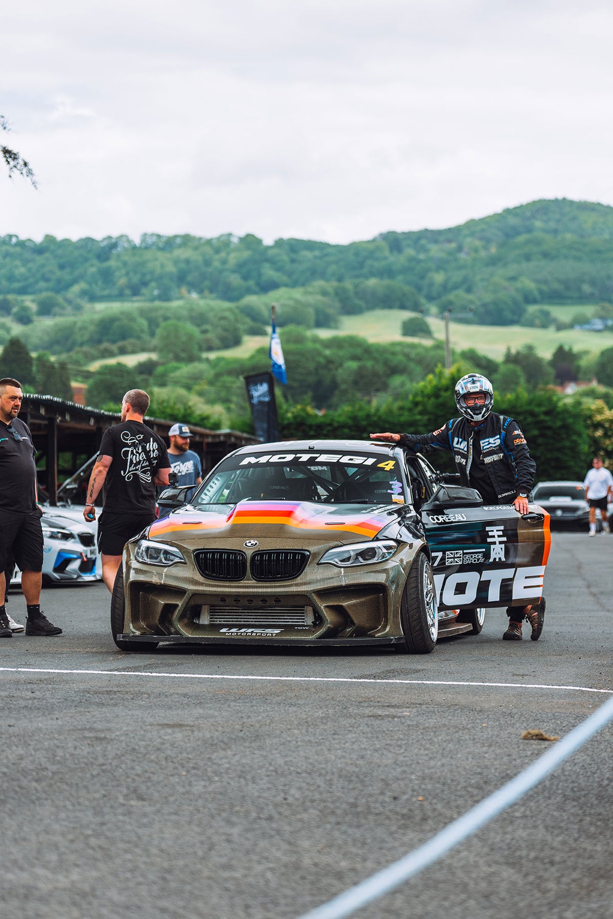 Drift car parked with driver and spectators nearby