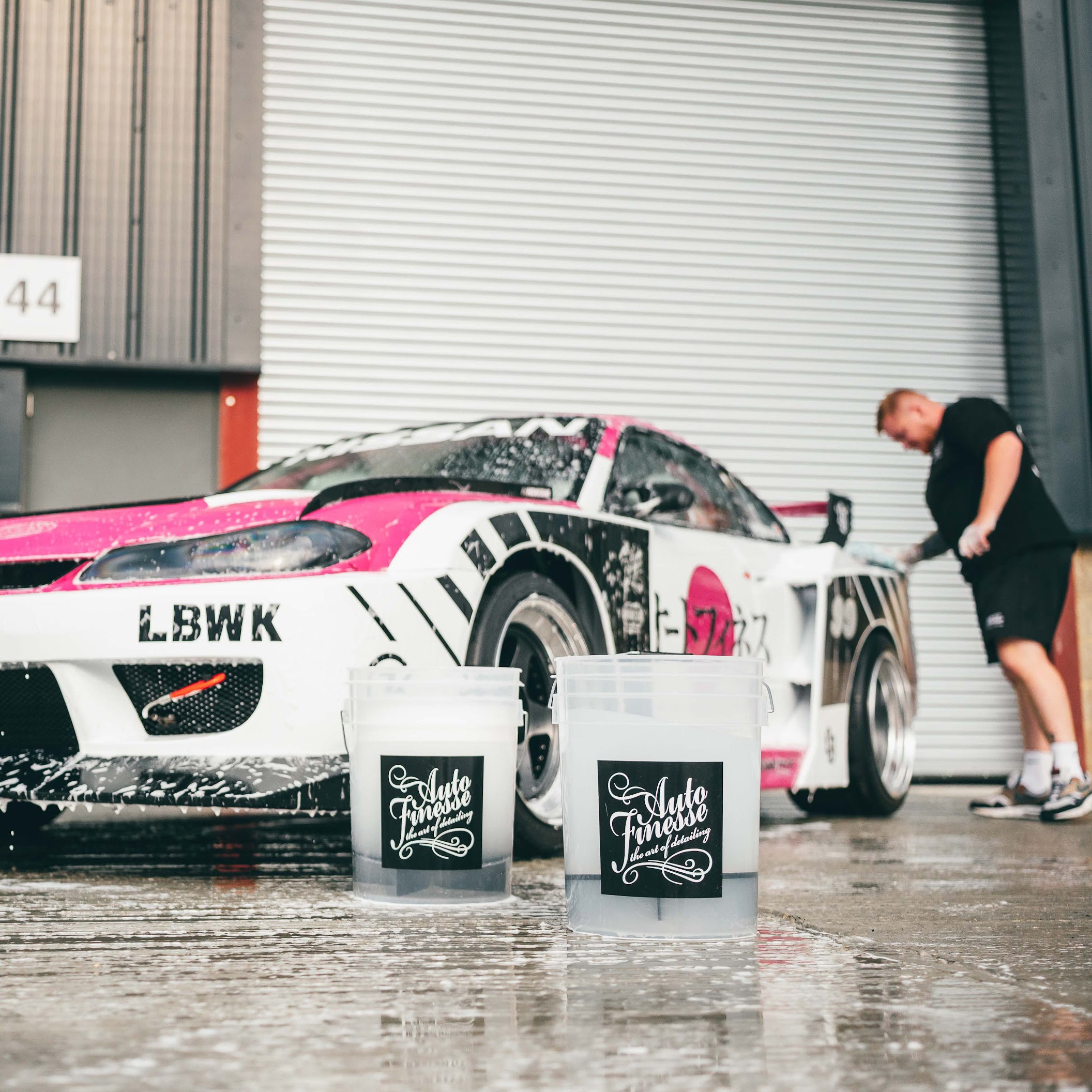 Man using 20L Auto Finesse detailing bucket while car detailing