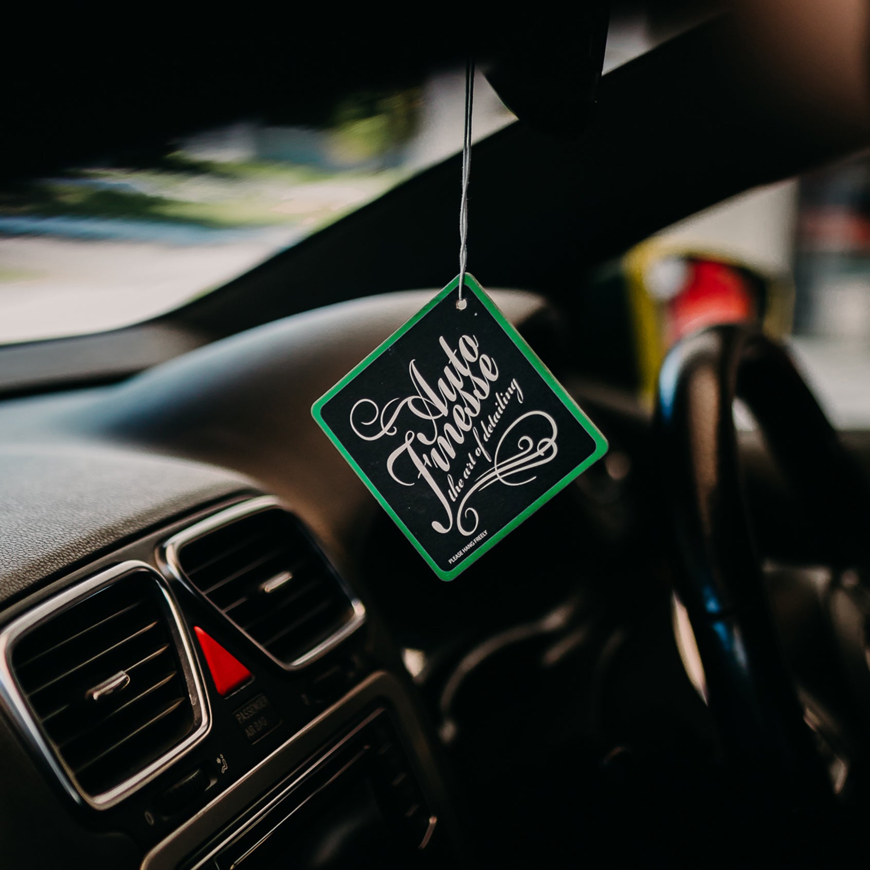 Green Sweet Shop Air Freshener is hanging from mirror